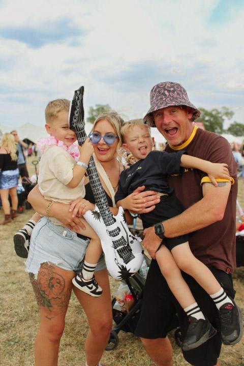 Family with young children and inflatable guitar small WEB Family at Sunshine Festival with young children and inflatable guitar small